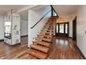 Bright entryway showcasing floating stairs with wooden treads and an accent fireplace with marble surround at 2828 N Illinois St, Indianapolis, IN 46208