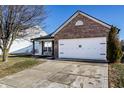 Single-Gathering home with a brick facade, well-manicured lawn, and a two-car garage at 3037 Knobstone Ln, Indianapolis, IN 46203