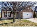 Single-Gathering home featuring a well-maintained lawn, brick accents, and an attached garage at 3037 Knobstone Ln, Indianapolis, IN 46203