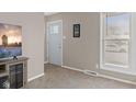 Living room featuring tan walls, carpet flooring, large window, and a white door at 313 Lawndale Dr, Plainfield, IN 46168