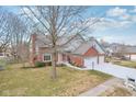 Beautifully landscaped home with brick and gray siding, offering curb appeal and a spacious yard at 3226 Raylin Dr, Indianapolis, IN 46227