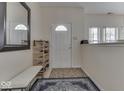 Bright entryway with white door, decorative rug, shoe rack, bench, and natural light at 387 Legacy Blvd, Greenwood, IN 46143