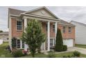 Two story home has a brick facade, a lawn and large columns at the entryway at 387 Legacy Blvd, Greenwood, IN 46143