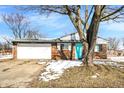 Charming brick home features an attached garage, and a pop of color with the bright blue front door at 5614 Personality Ct, Indianapolis, IN 46237