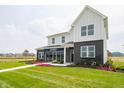 Attractive two-story model home with a modern design, showcasing a manicured lawn, and beautiful landscaping at 5879 Handbell Ln, Greenwood, IN 46143