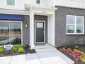 Close-up of the front door of the home, with the house number, brick details, and manicured landscaping at 5879 Handbell Ln, Greenwood, IN 46143