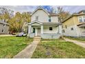 Charming two-story home with a covered front porch and well-maintained lawn and walkway at 638 W 30Th St, Indianapolis, IN 46208