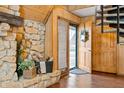 Inviting home entryway with stone accent wall, wood paneled walls, spiral staircase, and beautiful hardwood floors at 671 State Road 267, Mooresville, IN 46158