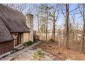 Beautiful exterior with stone chimney, gravel walkway, view of the lake, and path leading to the front door at 671 State Road 267, Mooresville, IN 46158