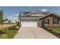 Stylish two-story home featuring a brick exterior, a two-car garage, and a well-maintained lawn at 7367 Broadview Ln, McCordsville, IN 46055