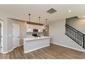 Bright, open kitchen with white cabinets, stainless steel appliances, a center island, and wood-look flooring at 7367 Broadview Ln, McCordsville, IN 46055