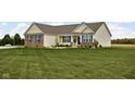 Attractive home with neat landscaping, pops of blue shutters, and an expansive front yard at 8225 W 825 N, Thorntown, IN 46071