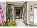 A close up view of the front door and address, framed by brick and garden at 8724 Faulkner Dr, Indianapolis, IN 46239