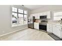 Well-lit kitchen with white cabinets, stainless steel appliances, and a large window offering plenty of natural light at 10669 Springston Ct, Fishers, IN 46037