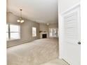 Bright living room featuring neutral carpet, fireplace, and access to the outside with lots of windows and natural light at 10669 Springston Ct, Fishers, IN 46037