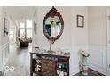 Inviting entryway with dark wood floors, decorative mirror, and a view into the cozy living area at 1083 Margate Dr, Greenwood, IN 46143