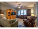 Inviting living room with hardwood floors, a ceiling fan, comfortable seating, and a built-in entertainment center at 12991 Pennington Rd, Fishers, IN 46037