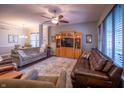 Spacious living room with hardwood floors, a ceiling fan, comfortable seating, and an entertainment center at 12991 Pennington Rd, Fishers, IN 46037