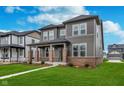 Charming two-story home with gray siding, brick accents, and well-maintained landscaping at 14390 Bishop Birch Pl, Carmel, IN 46032