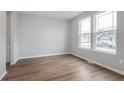 Bright, airy living room featuring wood floors and large windows showcasing the neighborhood at 14390 Bishop Birch Pl, Carmel, IN 46032