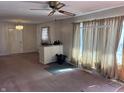 Spacious room featuring a ceiling fan, pink carpet, and light-filled window at 338 A St, Wilkinson, IN 46186