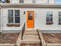 Close-up of the vibrant orange front door of a charming two-story home with window boxes at 422 E Main St, Lebanon, IN 46052