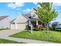 A well maintained home featuring a two-car garage, landscaped yard, and classic architectural details, ready for a new homeowner at 5648 Juniper Ct, Whitestown, IN 46075