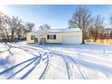 Charming yellow home with a large snow-covered front yard and attached garage at 5757 E 21St St, Indianapolis, IN 46218