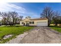 Quaint one-story home featuring an attached garage and a long driveway at 5757 E 21St St, Indianapolis, IN 46218