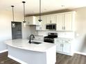 Modern kitchen featuring a marble island, stainless steel appliances, white cabinets and stylish pendant lighting at 618 Firefly Ct, Greenfield, IN 46140