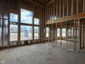 Spacious living room under construction featuring tall windows, wood framing, and open layout, showcasing the home's bright and airy design at 618 Firefly Ct, Greenfield, IN 46140