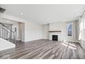 Open living room with hardwood floors, gas fireplace, and staircase at 6723 Collisi Pl, Brownsburg, IN 46112