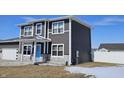 Two-story home with gray siding, white trim, blue front door, and an attached garage at 686 N Sobota Way, Trafalgar, IN 46181