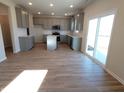 Bright, modern kitchen with gray cabinets, an island, stainless steel appliances, and wood floors at 6887 Seabiscuit Rd, Whitestown, IN 46075