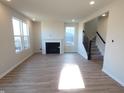 Spacious living room featuring wood floors, a fireplace, and staircase to the upper level at 6887 Seabiscuit Rd, Whitestown, IN 46075