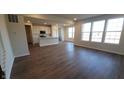 Open-concept living space showcasing hardwood floors and a seamless transition to the modern kitchen at 6895 Seabiscuit Rd, Whitestown, IN 46075