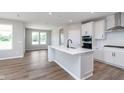 Bright, modern kitchen with a large island, stainless steel appliances, and pristine white cabinetry at 7026 Barrett Dr, Brownsburg, IN 46075