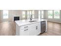 Stylish kitchen island with a stainless steel sink, built-in dishwasher and quartz countertops at 7026 Barrett Dr, Brownsburg, IN 46075