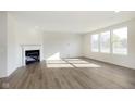 Spacious living room with wood-look floors, white walls, fireplace, and ample natural light at 7197 Barrett Dr, Brownsburg, IN 46112