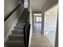 Inviting entryway featuring hardwood floors, staircase with black railing, and an office with French doors at 750 Oakleaf Dr, Greenfield, IN 46140