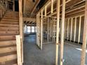 View of the home's unfinished interior displaying exposed wood framing, stairs, and the future location of the rooms at 750 Oakleaf Dr, Greenfield, IN 46140