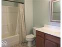 Cozy bathroom features a shower with curtain, toilet, and wood vanity with light countertop at 8148 Shores Edge Way, Indianapolis, IN 46237