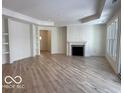Spacious living room with a fireplace, built-in shelving, hardwood flooring, and abundant natural light at 9124 Bryce Cir, Zionsville, IN 46077