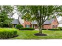 Traditional brick home with a lush green lawn and mature trees at 13631 Singletree Ct, Carmel, IN 46032