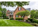 Inviting brick home with manicured lawn and mature trees at 13631 Singletree Ct, Carmel, IN 46032