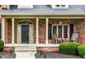Inviting front porch with rocking chairs and charming details at 13631 Singletree Ct, Carmel, IN 46032