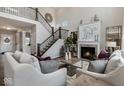 Elegant living room with a fireplace, staircase with iron railings, and neutral color palette at 19763 Atwater Ave, Sheridan, IN 46069