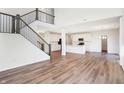 Open concept living area with hardwood floors, a staircase with iron railings, and white kitchen at 19763 Atwater Ave, Sheridan, IN 46069