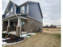 Side view of the house, showcasing the brickwork, siding, and well-maintained lawn at 1986 Mccormick Dr, Greenwood, IN 46143
