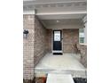 Cozy front porch with brick columns, seating area, and a stylish black front door at 1986 Mccormick Dr, Greenwood, IN 46143